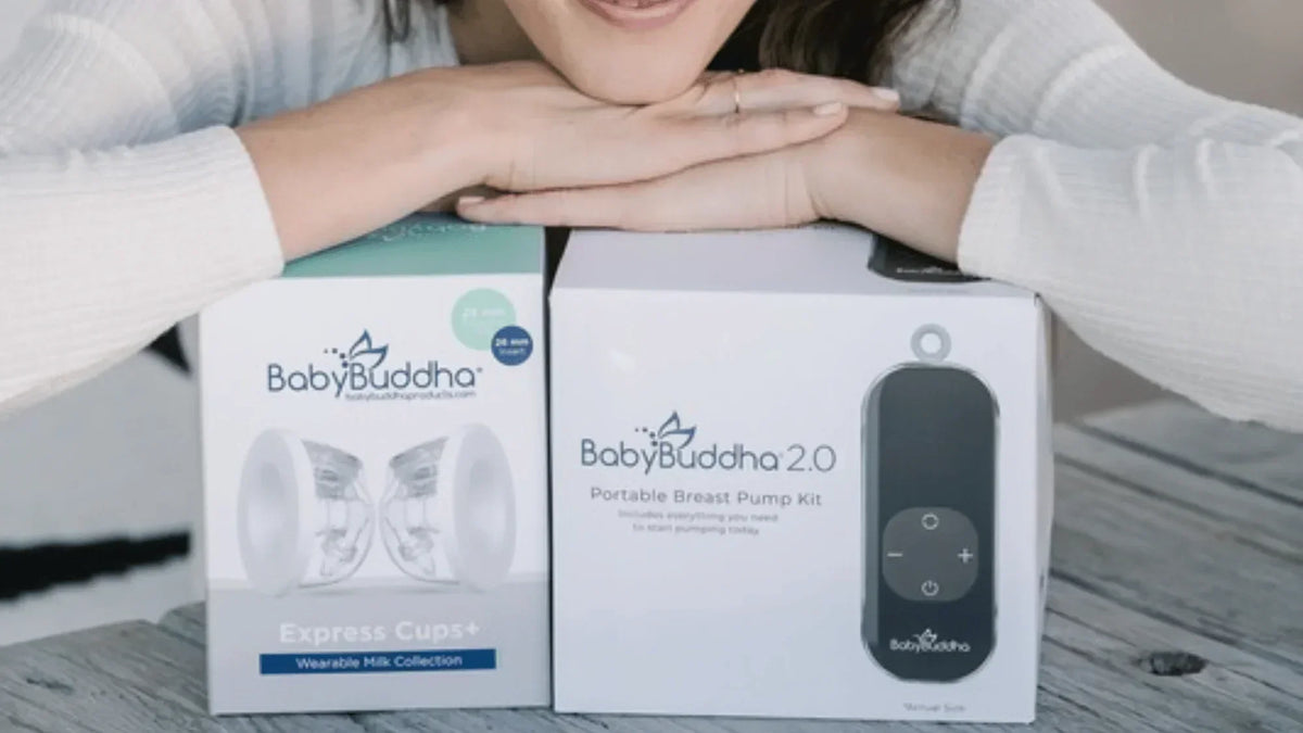 Parent leaning on BabyBuddha breast pump and wearable collection cup boxes displayed on a table.
